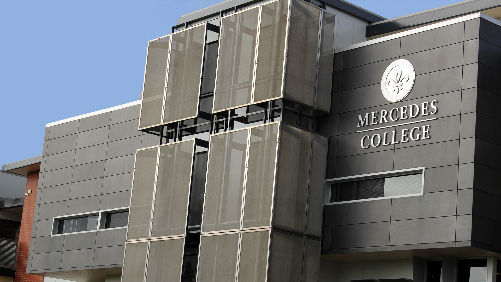Mercedes College building exterior with modern grey facade and large vertical sunshades.